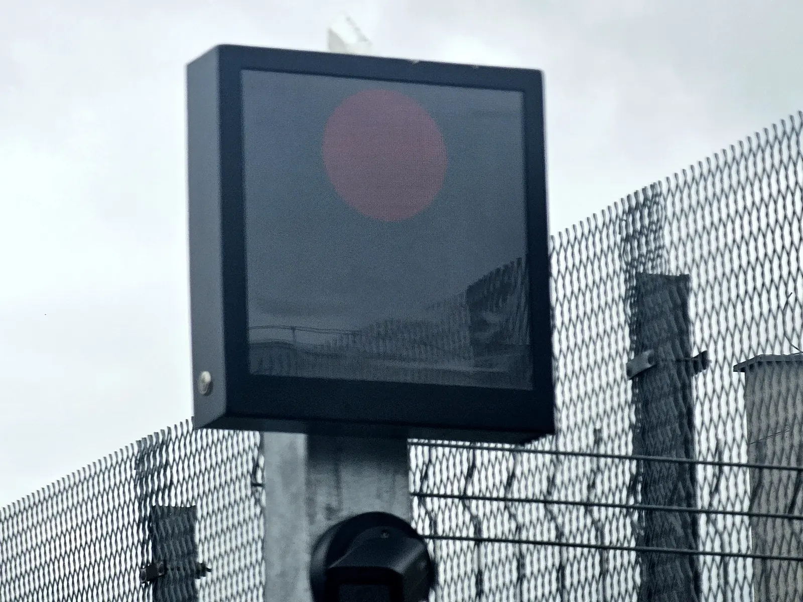 LED panel s červeným signálem stop na sloupu u oplocení