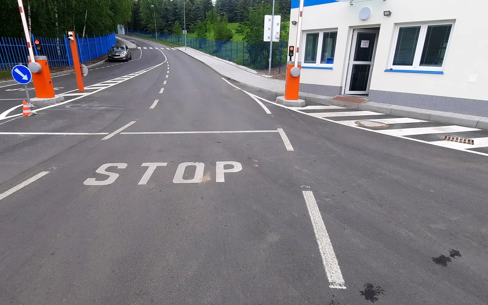 Vjezd s dvojicí závor a semafory před vrátnicí